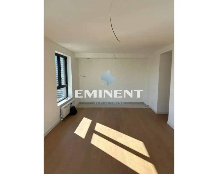Empty room with parquet flooring and a window.
