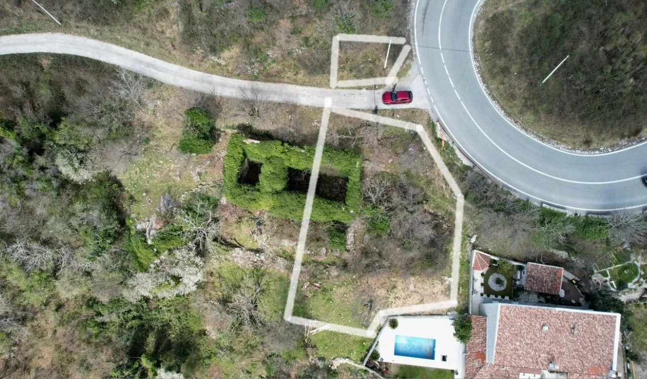 Pogled iz vazduha na parcelu sa ucrtanim granicama, ruševinom i pristupnim putem.