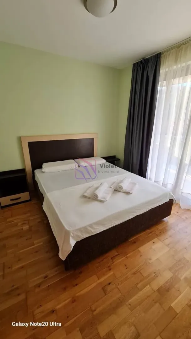 Namještena spavaća soba sa bračnim krevetom i drvenim podom.