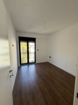 Prazna soba sa parketom i izlazom na balkon. - image 4