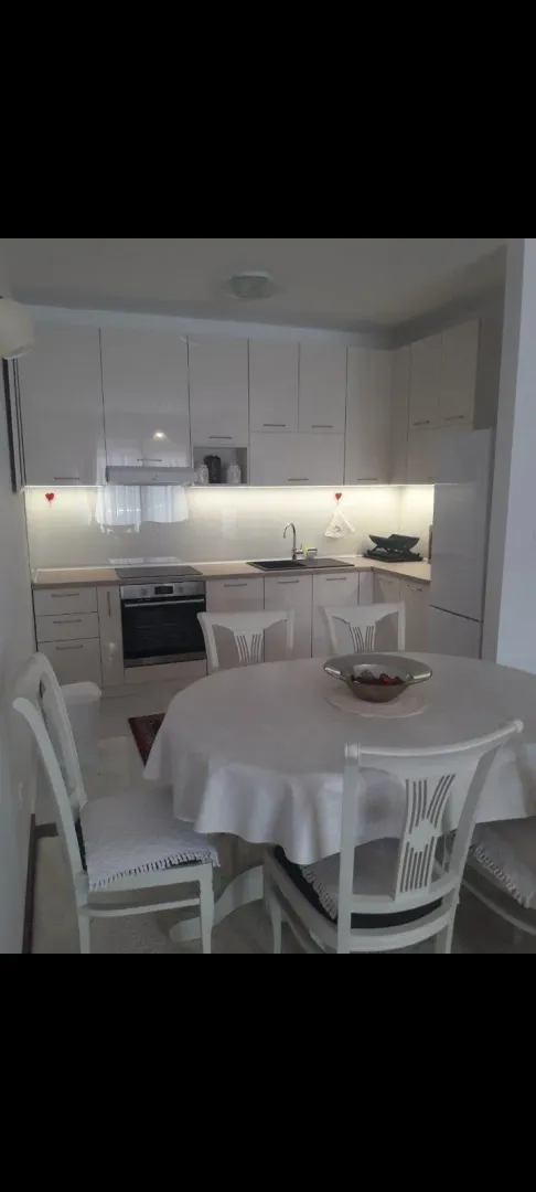 A kitchen with a dining table and white cabinets.