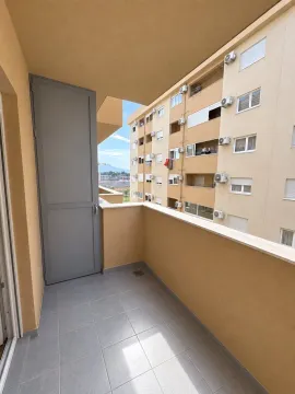 Manji popločani balkon sa vratima i pogledom na susjednu zgradu. - image 4