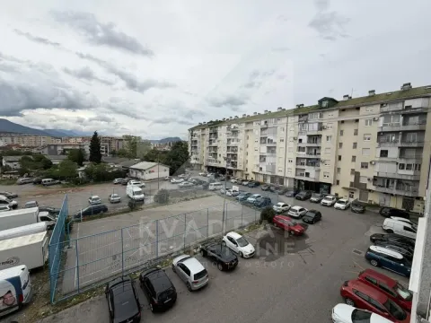 View from the window overlooking surrounding buildings and parking lot. - image 13