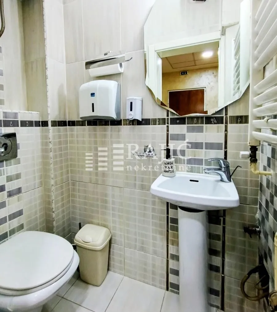 Small bathroom with a sink, toilet, and mirror.