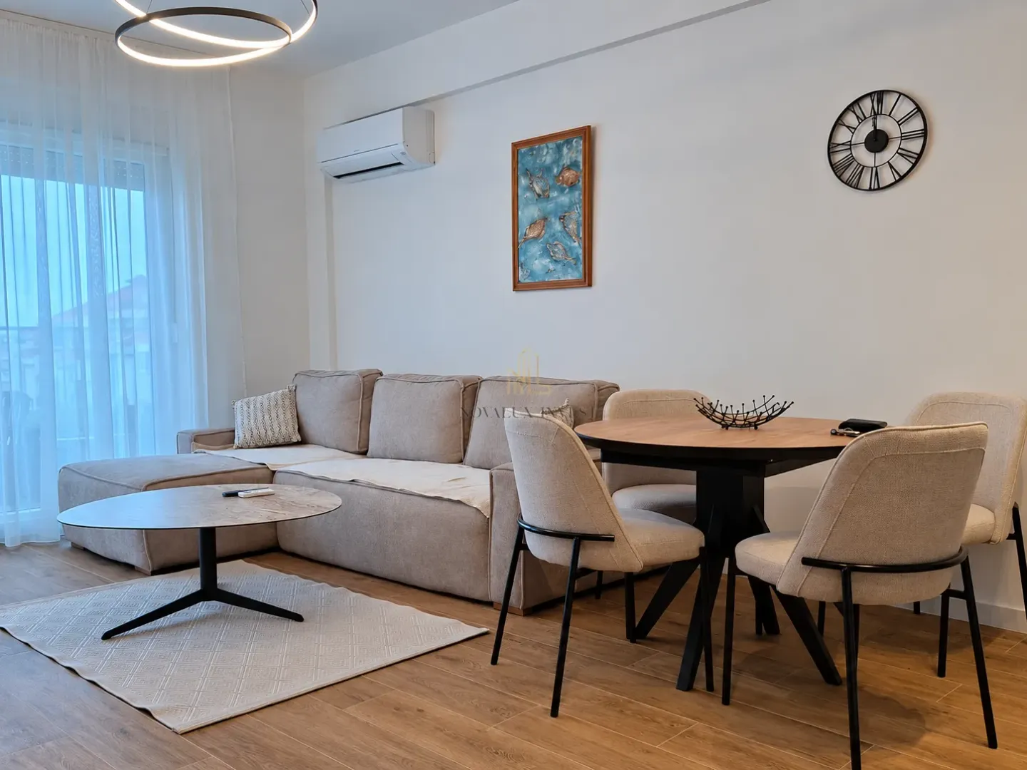 Living room with a sofa, dining table, and chairs.