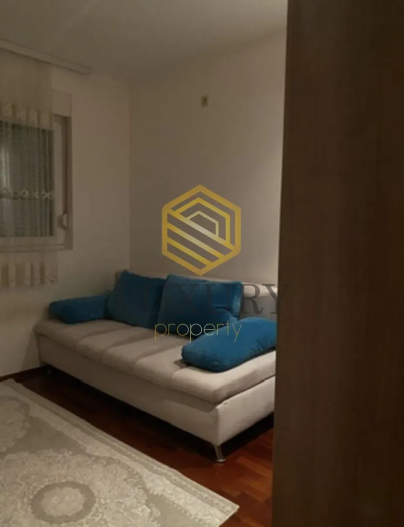 Small living room with a light-colored sofa and blue pillows.