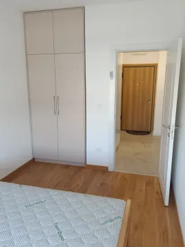 Furnished bedroom with a built-in wardrobe and wooden floor. - image 7