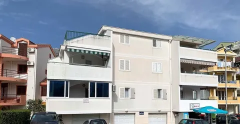 Exterior view of the apartment building with terraces and parked cars in front. - image 15