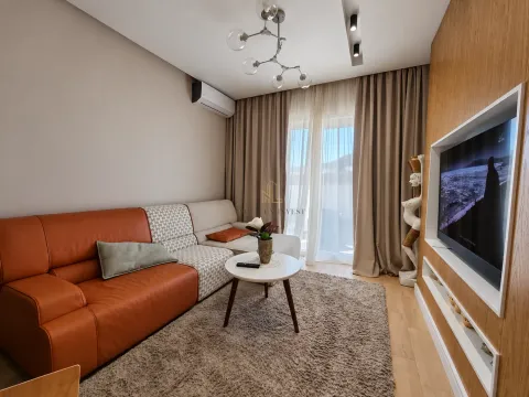 Dnevna soba sa ugaonom garniturom, stočićem i zidnim televizorom. - image 2
