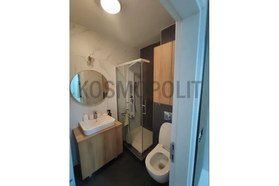 Savremeno opremljeno kupatilo sa tuš kabinom, umivaonikom i toaletom.