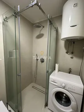 Bathroom with a walk-in shower, water heater, and washing machine. - image 3