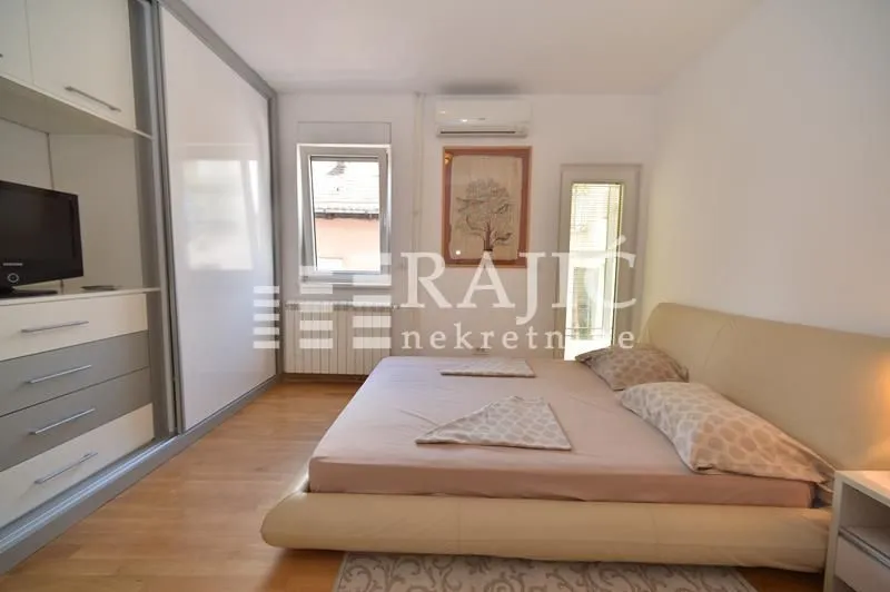 Furnished bedroom with a large double bed, wardrobe, and air conditioning.