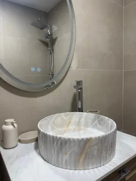 Modern bathroom with a basin and a round mirror. - image 7