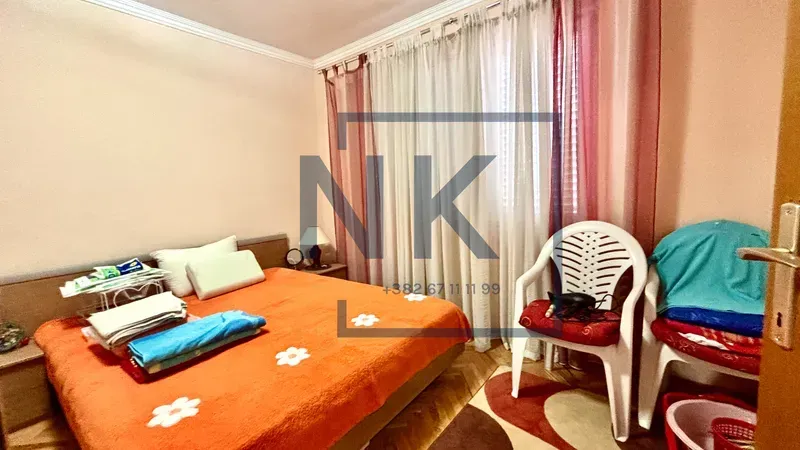 Bedroom with a double bed and a window with curtains.
