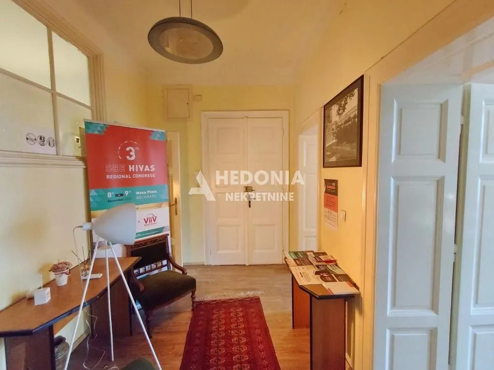Hodnik sa drvenim podom, stolovima i promotivnim materijalom.