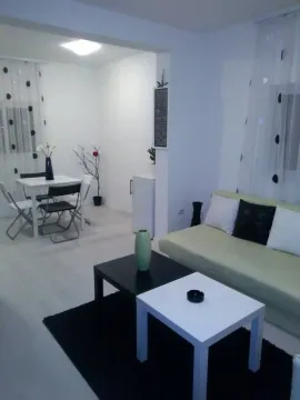 Svijetla dnevna soba sa garniturom za sjedenje i trpezarijskim stolom u pozadini. - image 2