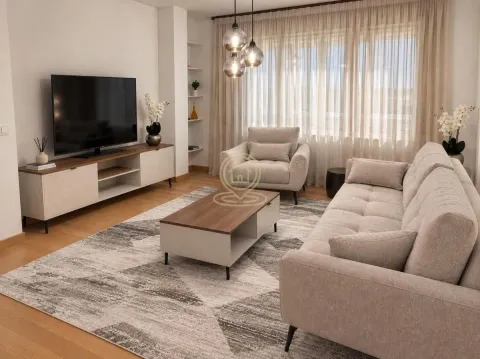 Dnevna soba sa garniturom, stočićem, televizorom i velikim prozorom sa zavesama. - image 8