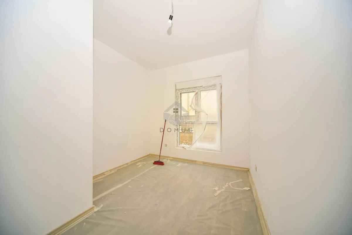 Prazna neuređena prostorija sa prozorom i zaštitnom folijom na podu.