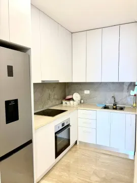 Modern kitchen with white cabinetry and built-in appliances. - image 5