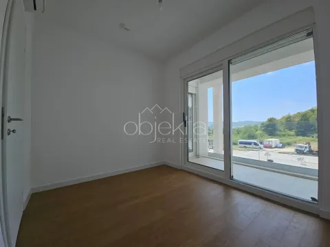 Prazna soba sa drvenim podom i velikim balkonskim vratima. - image 6