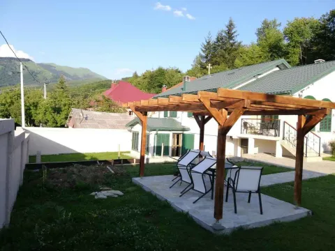 Dvorište sa drvenom pergolom, garniturom za sjedenje i pogledom na planine. - image 2