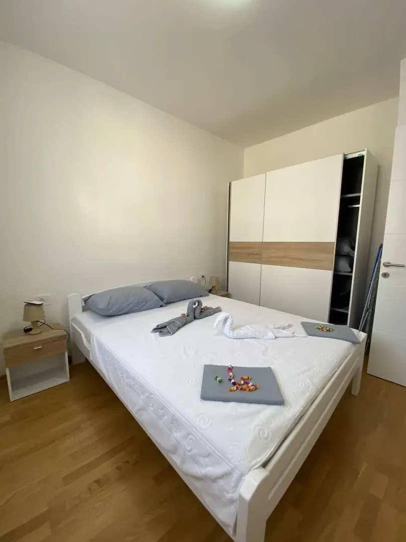 Furnished bedroom with a double bed and a wardrobe.