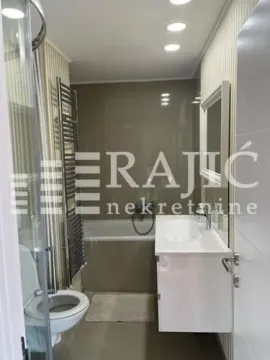 Modern equipped bathroom with a bathtub and a sink. - image 6