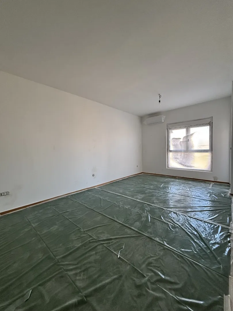 Prazna prostorija sa bijelim zidovima i zaštitnom folijom na podu.