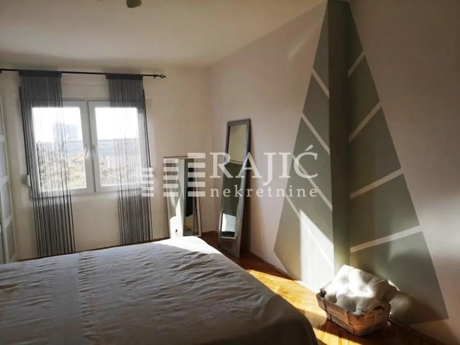 Furnished bedroom with a double bed and a window.