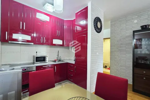 Kitchen with glossy red cabinets and a dining table in the foreground. - image 2