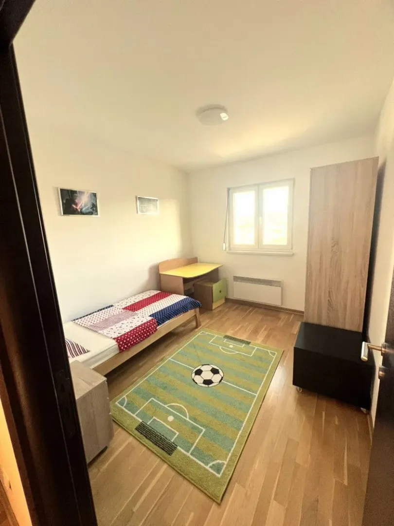 Children's bedroom with a bed, desk, and wardrobe.