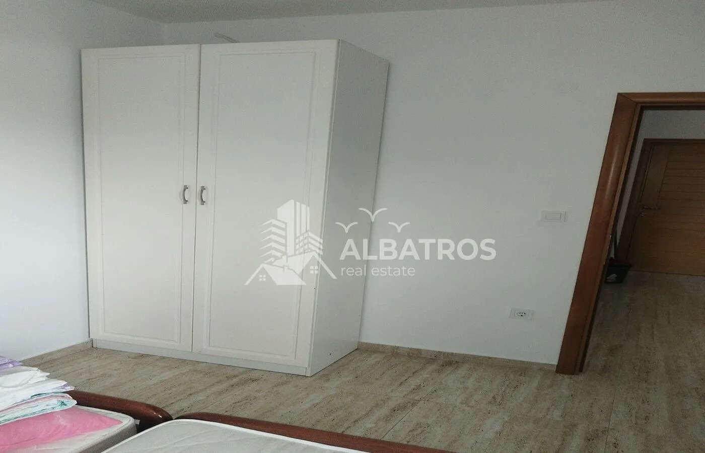 Bedroom with a white wardrobe and a bed.