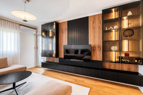 Modern living room featuring wooden wall panels, built-in lighting, and a television. - image 2