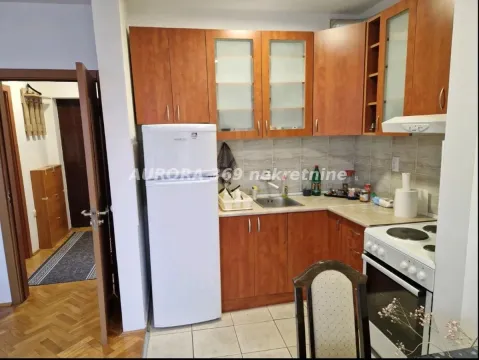 Small kitchen with wooden cabinets, refrigerator, and stove. - image 5