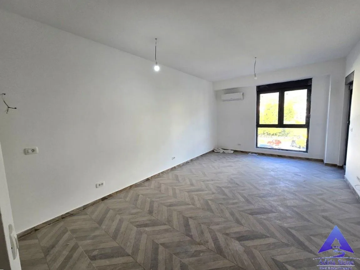 Empty room with white walls and wooden flooring.