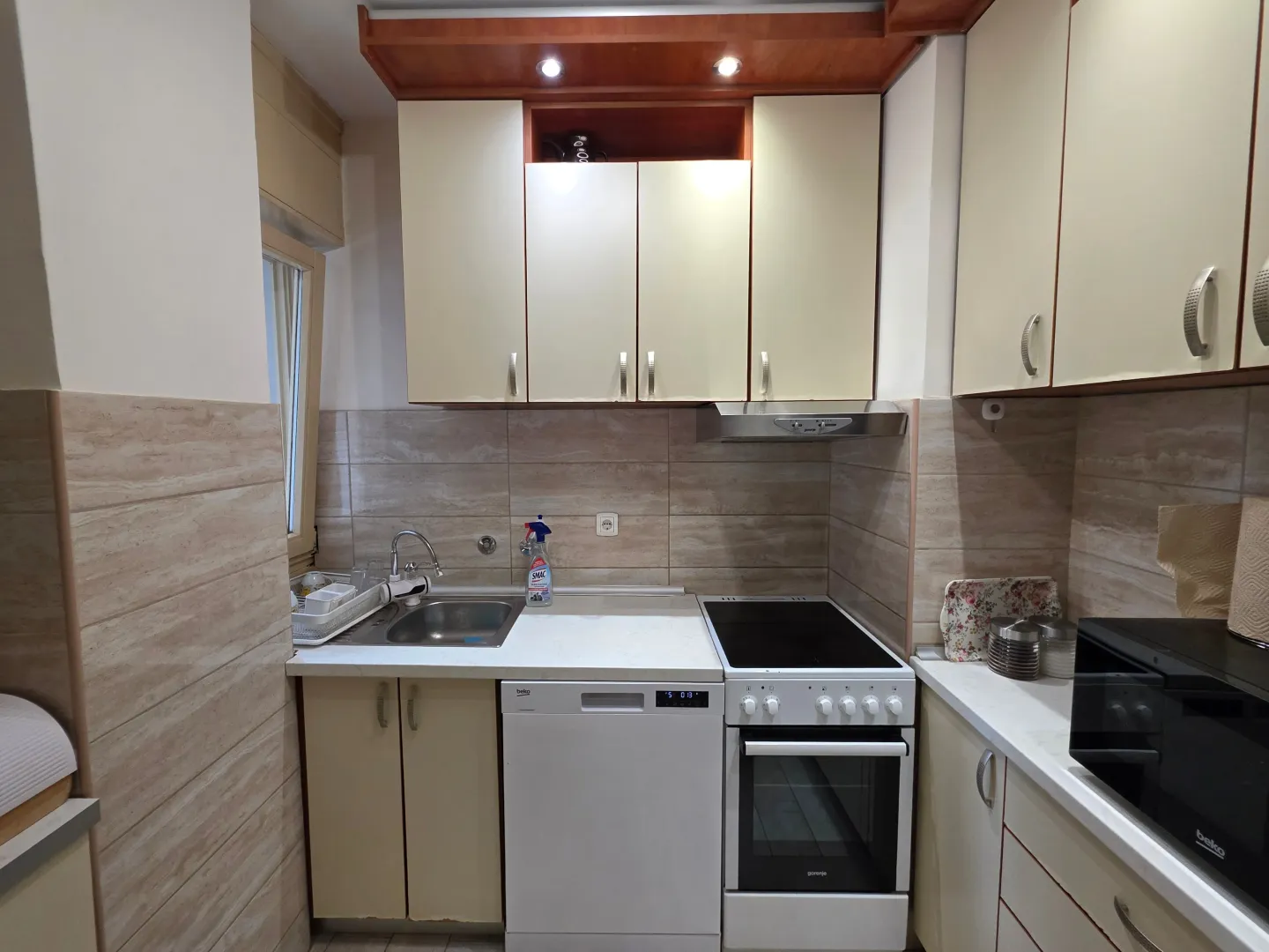 Compact kitchen with a sink, built-in cooktop, and kitchen cabinets.