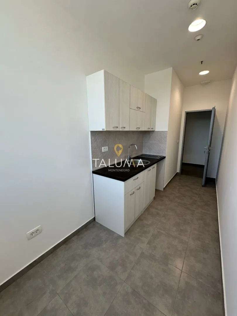Small kitchen with white cabinets and dark countertop.