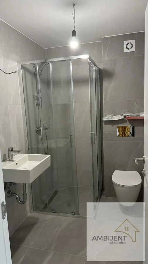 Novoopremljeno kupatilo sa tuš kabinom, umivaonikom i wc šoljom.