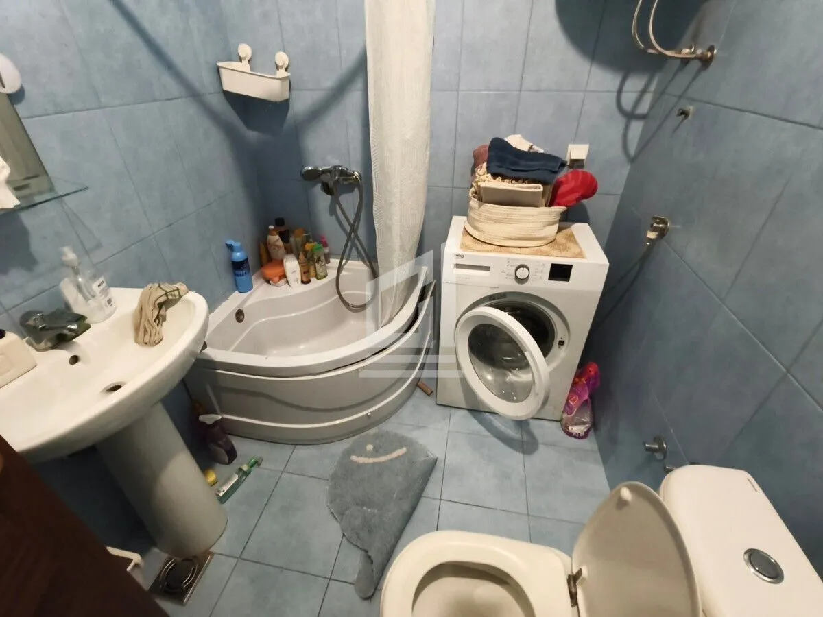 Kupatilo opremljeno umivaonikom, kadom, veš mašinom i toaletom.