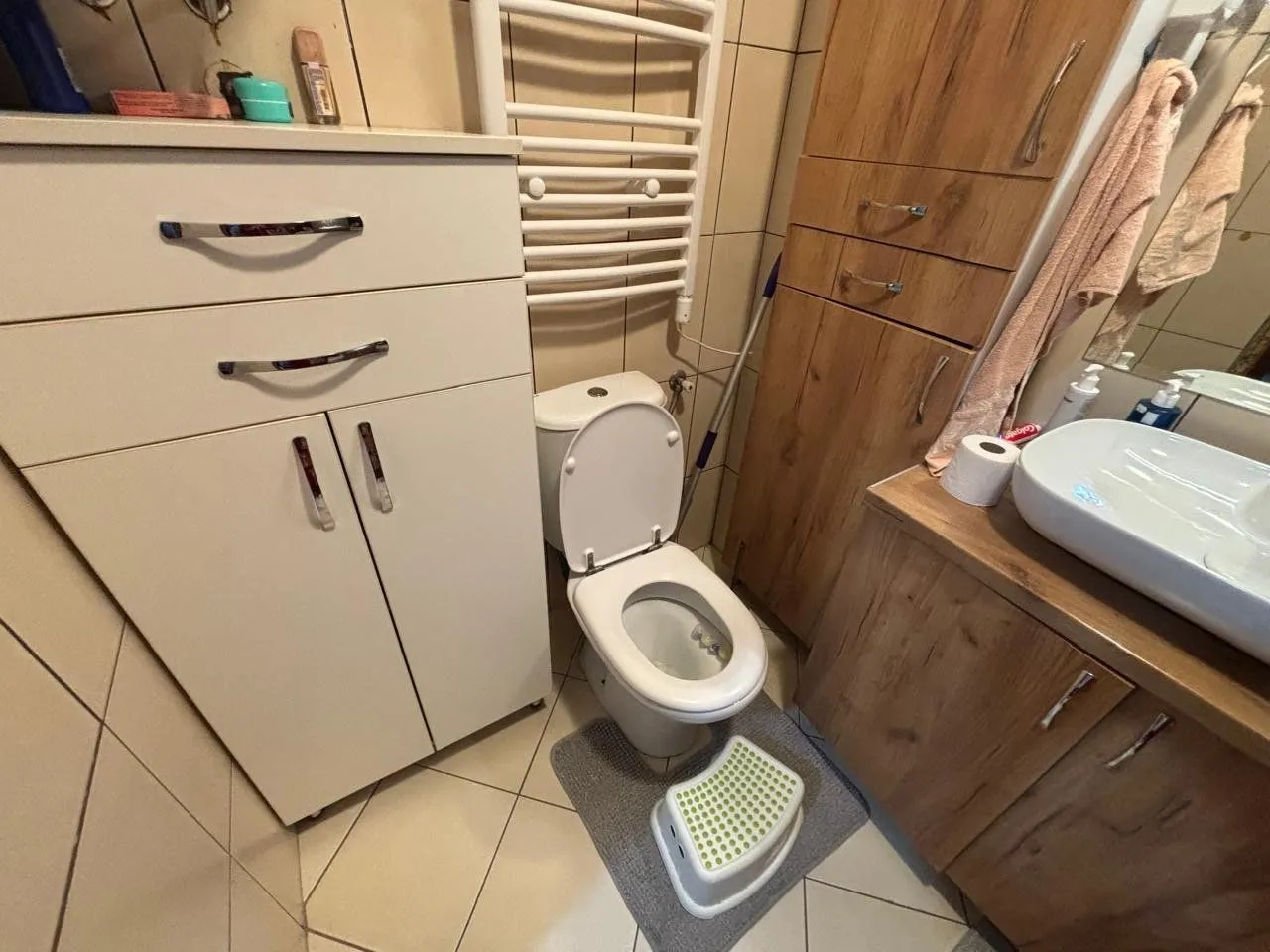 Kupatilo opremljeno sanitarijama i drvenim elementima.