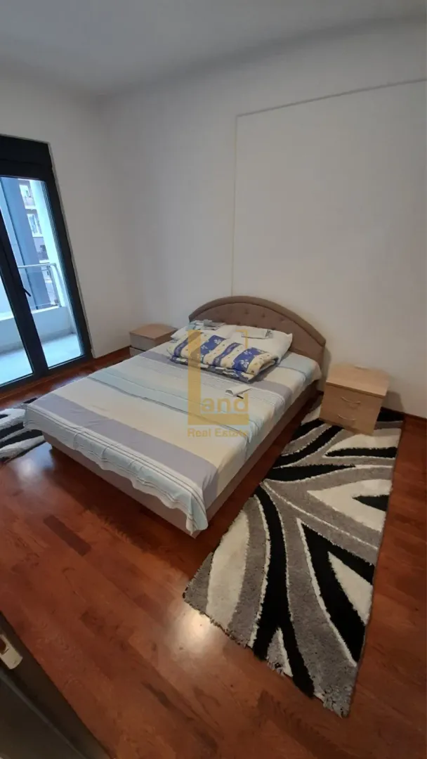Furnished bedroom with a double bed, nightstands, and a rug.