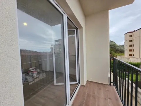 Manji popločani balkon sa crnom ogradom i pogledom na okolne zgrade. - image 7