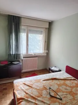 Nameštena spavaća soba sa krevetom, prozorom i radijatorom. - image 5