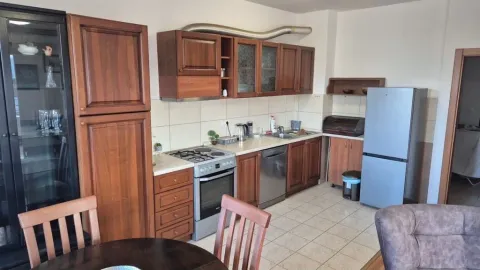 Kitchen equipped with wooden cabinets, stove, and refrigerator. - image 6