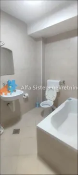 Bathroom equipped with a bathtub, washbasin, and toilet. - image 19