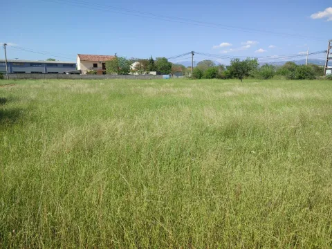 Veliki travnati plac sa objektima u pozadini. - image 7