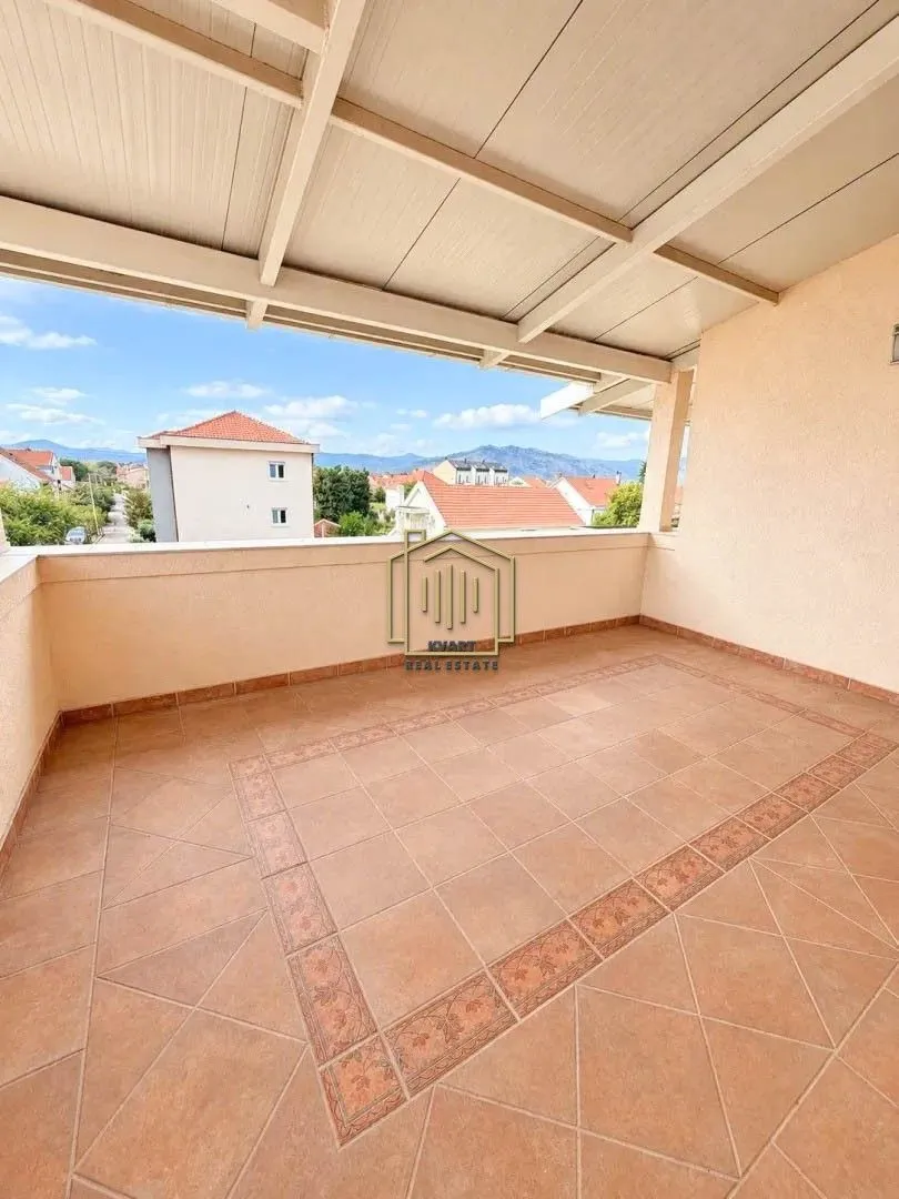 Covered terrace with ceramic tiles and a view of the surroundings.