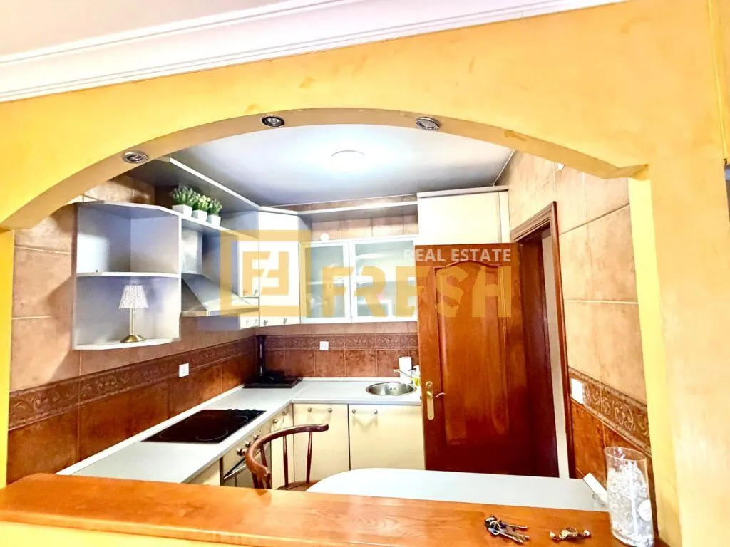 Small kitchen with fitted units and an arched doorway.