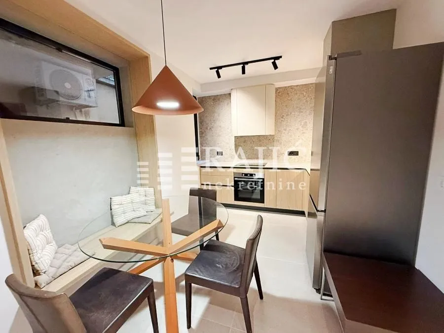 Modern kitchen with dining area and built-in appliances.