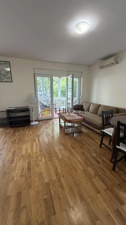 Living room with a sofa, dining table, and access to the terrace.